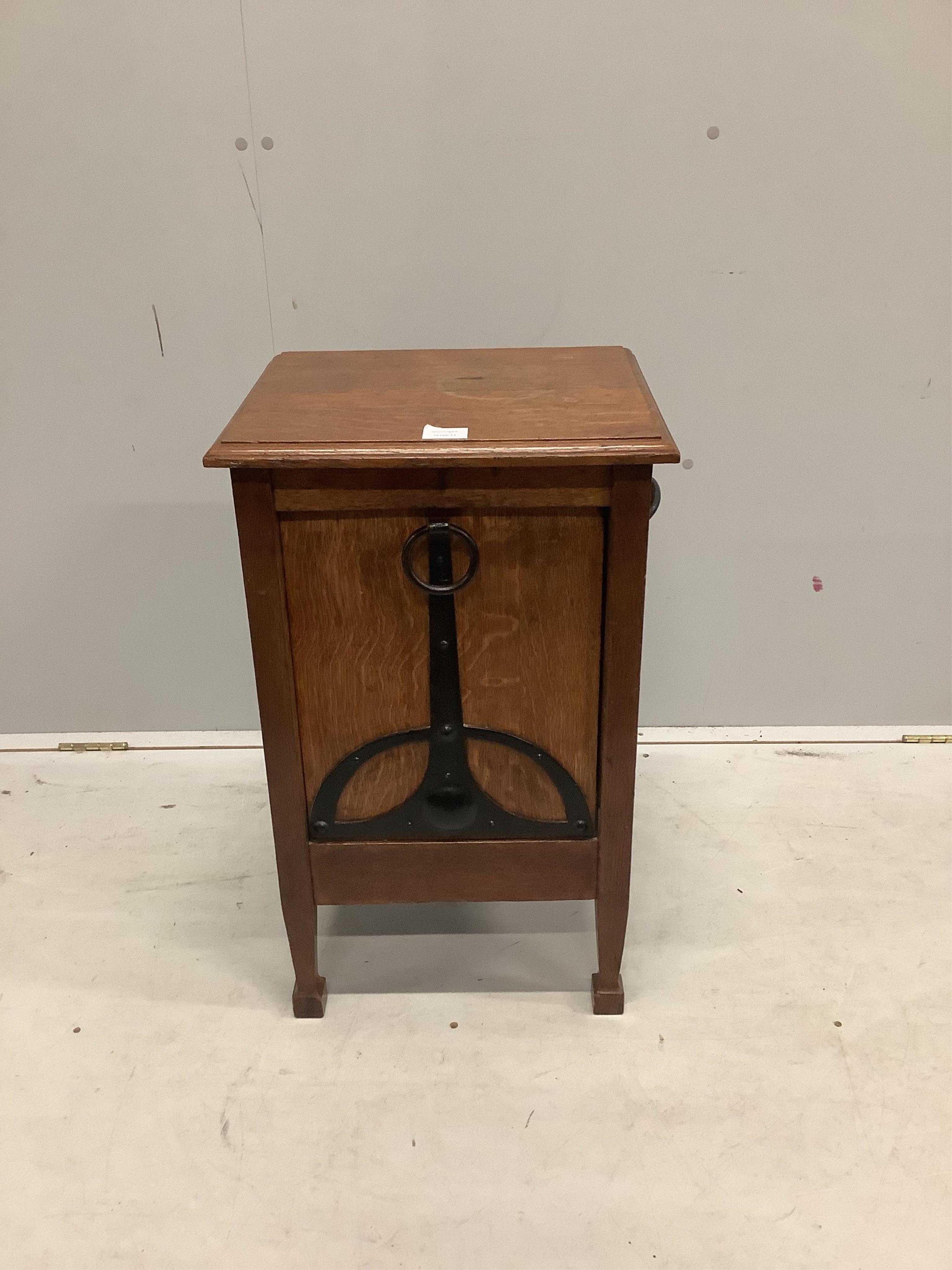 An Arts and Crafts oak coal purdonium, the fall front with a wrought iron handle and side carrying handles, together with a liner and shovel, width 42cm, depth 36cm, height 70cm. Condition - poor to fair